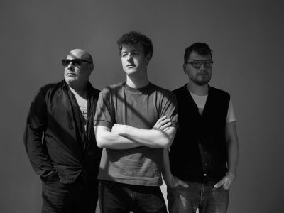 Black and white image of the Fabian Willmann Trio standing smiling next to one another